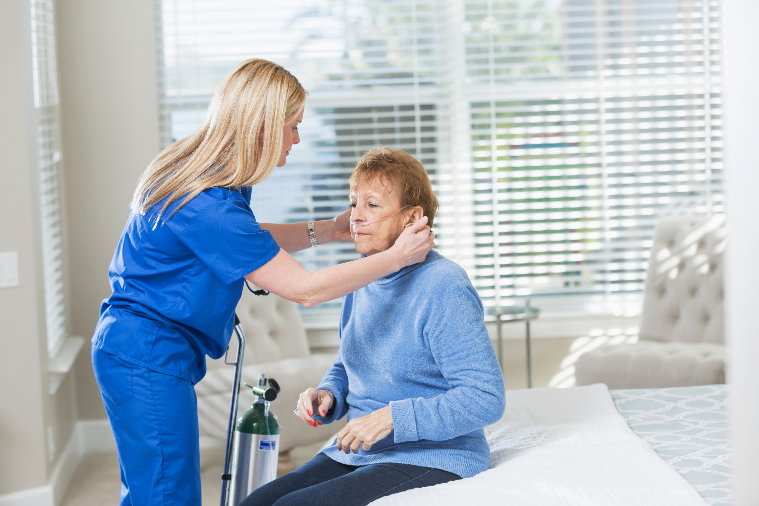 Nurse helping senior woman with oxygen therapy