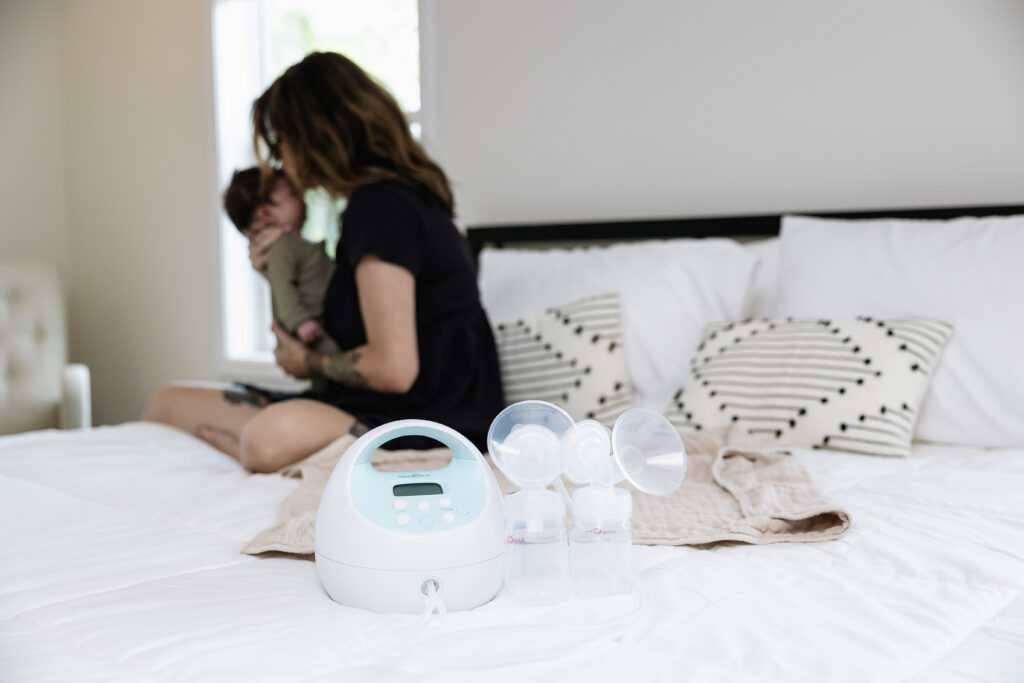 women in bed with baby and breast pump