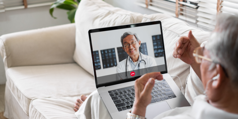 Man on couch speaking with doctor on telehealth call